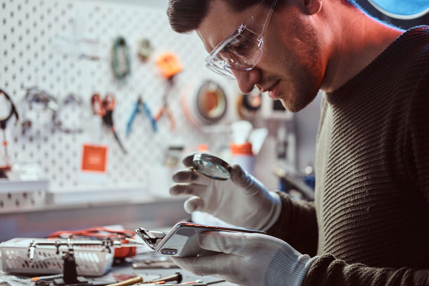 Electronic technician repair damaged smartphone in the workshop